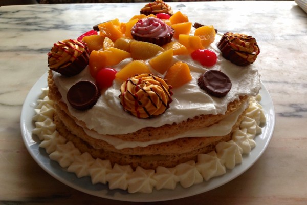 Una rica tarta decorada con fruta y bombones