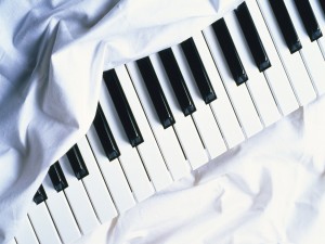 Teclas de un piano sobre una sabana blanca