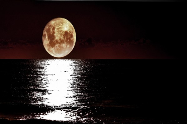 La luz de la luna llena reflejada en la superficie del mar