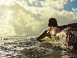 Chico en el mar sobre una tabla de surf