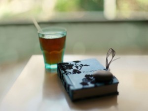 Vaso de té junto a un libro cerrado