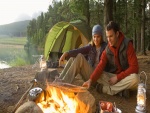 Pareja de acampada preparando la comida al fuego