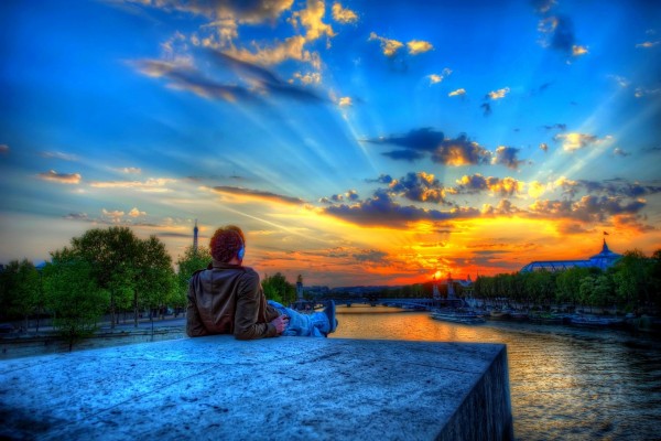 Chico contemplando un bonito amanecer en París