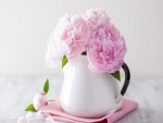 Peonías rosadas en un florero blanco