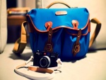 Cámara Leica junto a un bolso azul