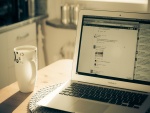 Taza de café junto a un MacBook