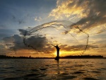 Pescador lanzando una red en el río