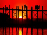 Gente en un puente admirando la puesta de sol
