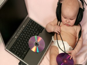 Bebé escuchando música en un ordenador portátil