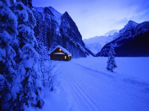 Cabaña iluminada en la nieve