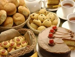 Mesa con galletas, pasteles y tazas de un divino té