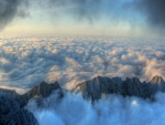 Picos montañosos sobresaliendo del mar de nubes