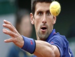 El tenista Novak Djokovic mirando con atención la pelota