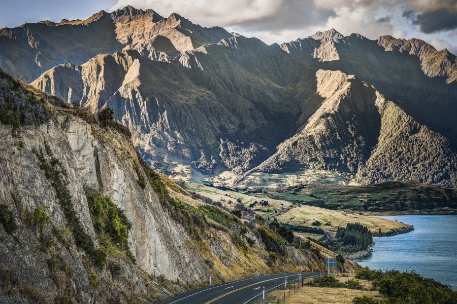 Carretera entre montañas y un lago