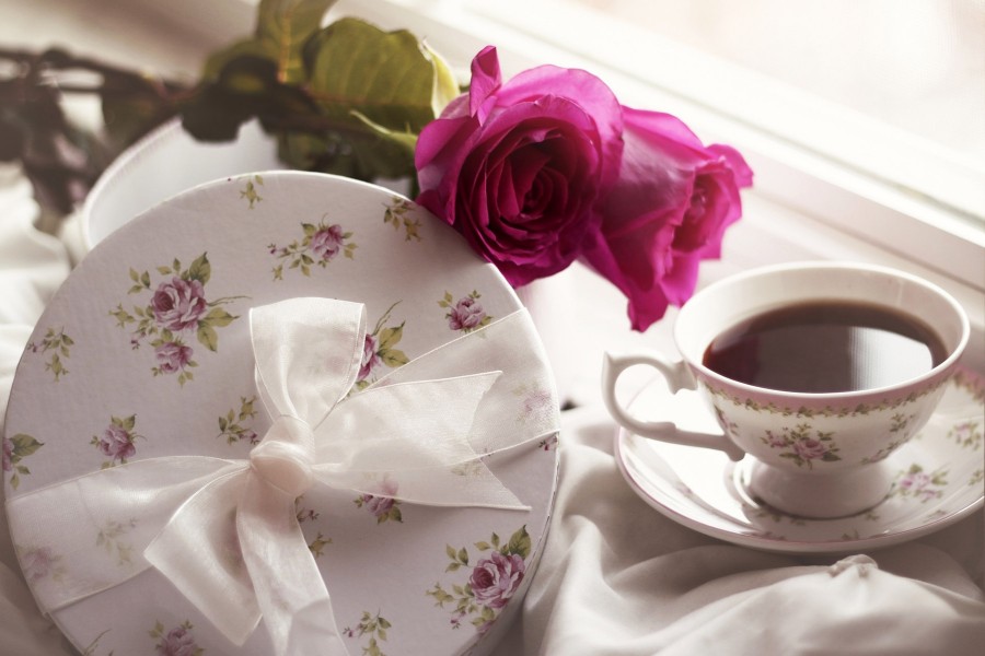 Dos rosas junto a una taza de té