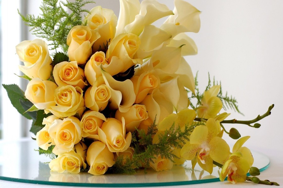 Centro de mesa amarillo con rosas, calas y orquídeas