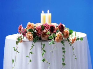 Postal: Arreglo floral con velas sobre una mesa