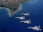 Cuatro aviones de combate sobrevolando el mar