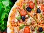 Exquisita pizza con aceitunas negras, tomates cherry, pimientos y queso