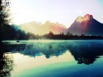 Sol iluminando el lago y las montañas