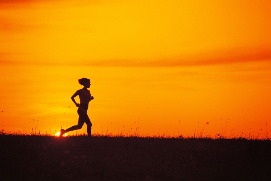 Mujer practicando running a la salida del sol