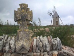 Molino de viento junto a una cruz de piedra