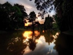 Amanecer reflejado en el lago de un parque