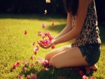 Muchacha jugando con pequeñas flores rosas