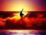Un hombre practicando surf en la puesta del sol