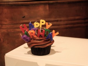 Cupcake de chocolate con con velas de "Feliz Cumpleaños"