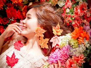 Chica feliz entre flores y hojas