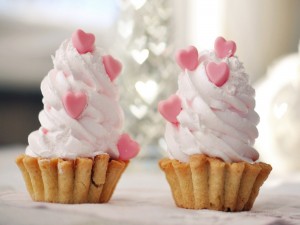 Dos ricos pasteles con corazones rosas