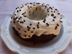 Un rico bundt cake cubierto de crema y pepitas de chocolate