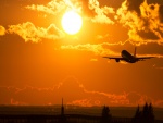 Avión despegando hacia el sol