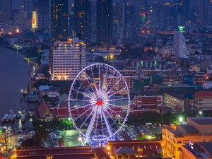 Vista nocturna de una noria y la ciudad de Bangkok