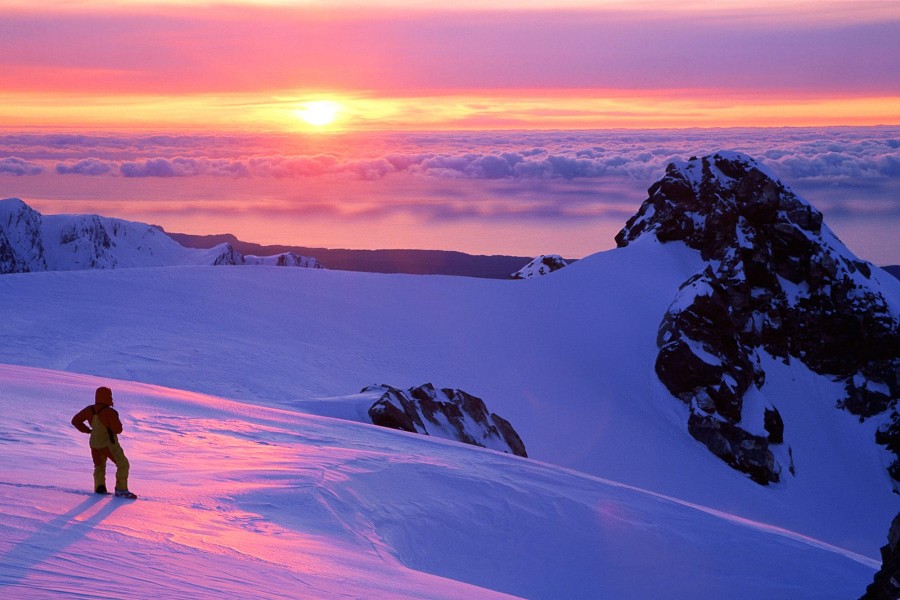 Hombre contemplando el amanecer en la montaña