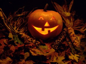 Postal: Calabaza de Halloween sobre hojas otoñales
