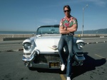 Arnold Schwarzenegger sentado en un Cadillac