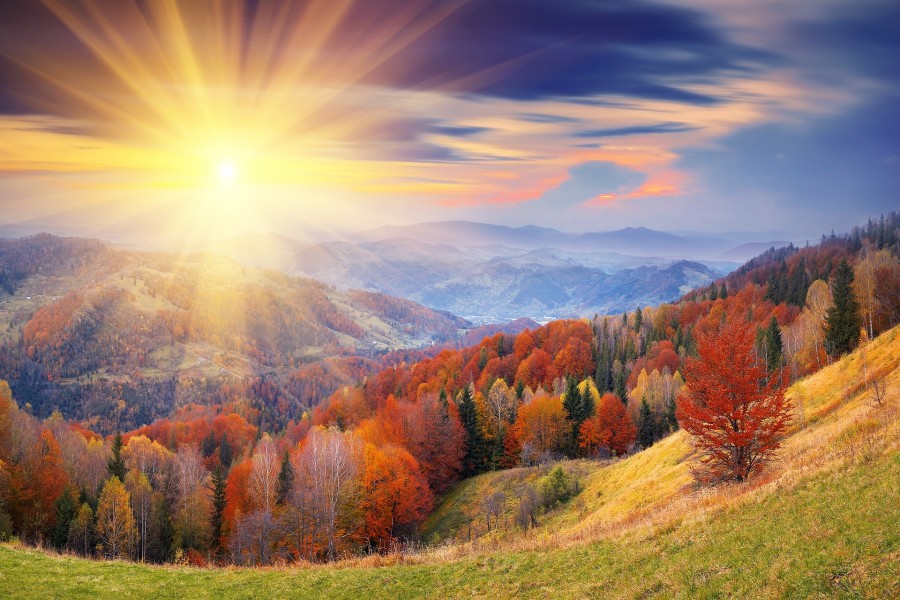 Los rayos del sol iluminan las colinas otoñales