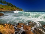 Las revueltas olas del mar lavan unas rocas en la costa