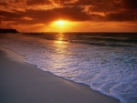 Sol iluminando la playa al amanecer