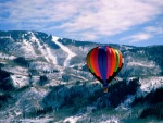 Globo volando sobre montañas nevadas