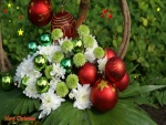 Una hermoso arreglo navideño con bolas y flores
