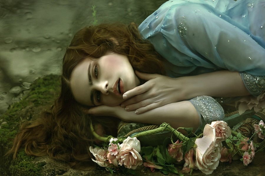 Mujer tumbada junto a unas flores