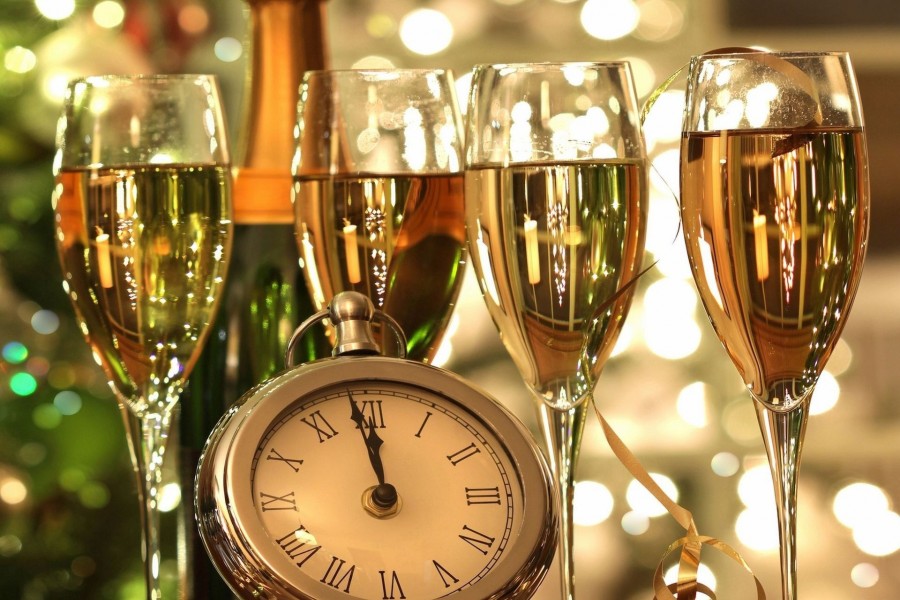 Copas con champán y un reloj marcando la llegada del Nuevo Año
