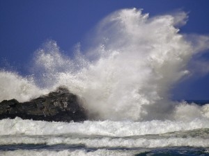 Gran ola chocando contra la roca