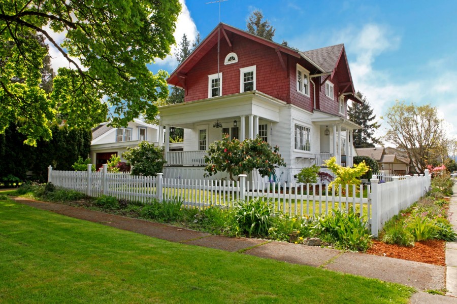 Hermosa casa de dos pisos con jardines y cerca de madera