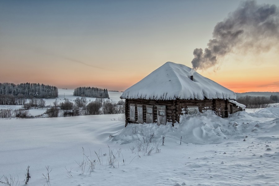 Casa de madera con chimenea en una mañana invernal