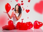 Mujer feliz con globos rojos en forma de corazón