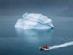 Personas en un bote contemplando un iceberg en el mar Ártico